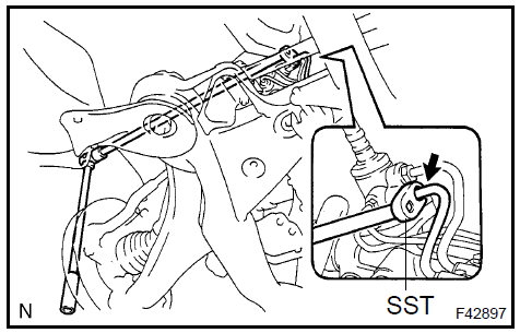 c. Remove the nut and disconnect the return tube clamp.