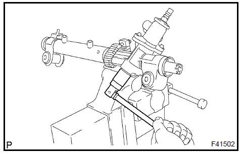 q. Using a punch and a hummer, stake the rack housing cap