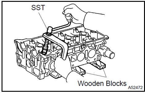 c. Using a plastic−faced hammer and a discarded valve with