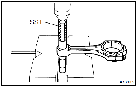 c. Using a pin hole grinder, hone the bushing to obtain the